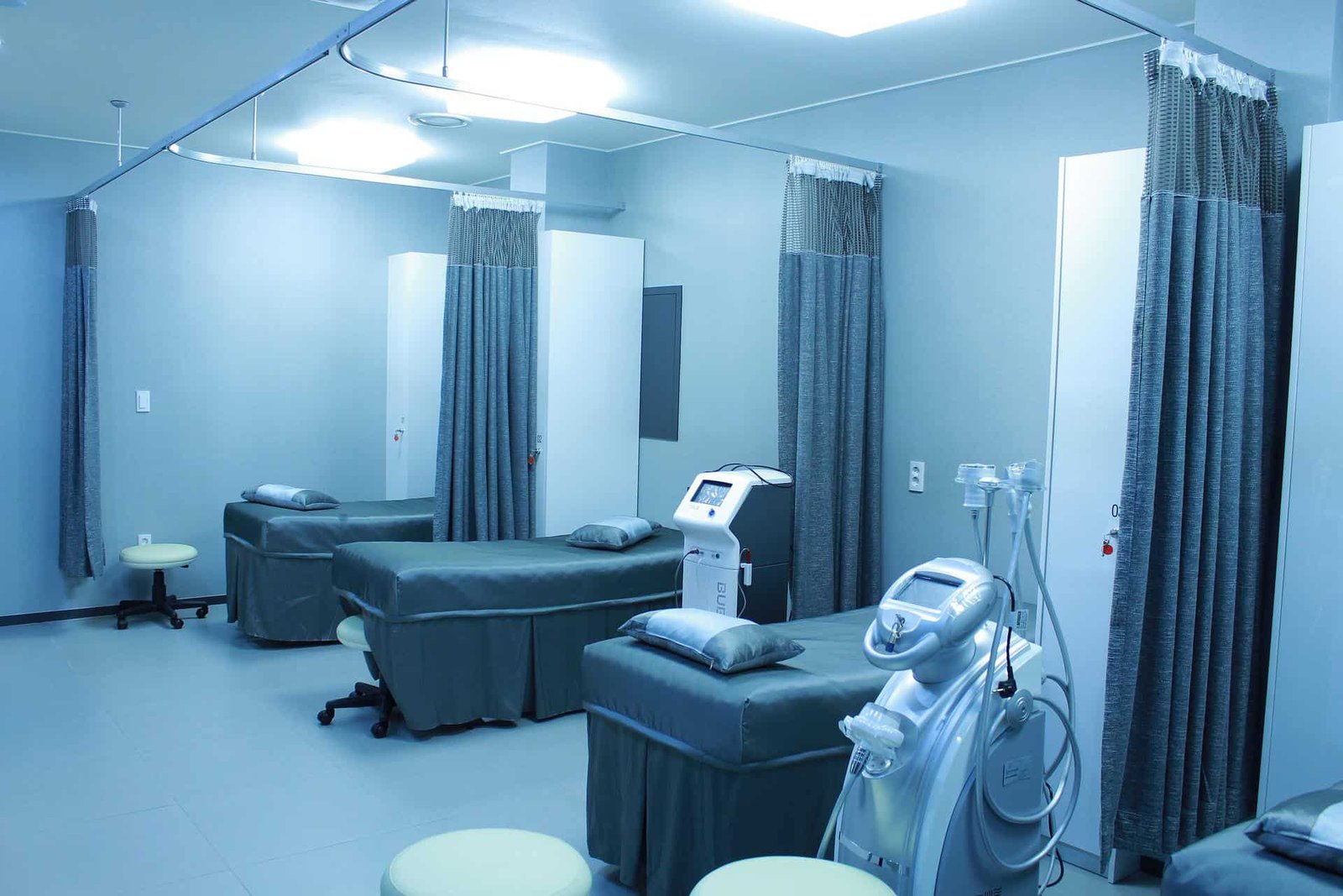 A hospital ward with several exam beds and partitions. 