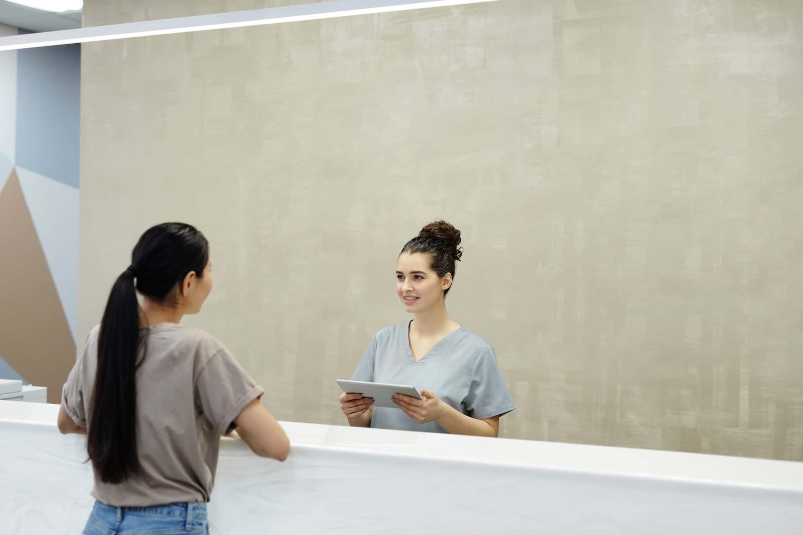 patient talking to a receptionist at a clinic