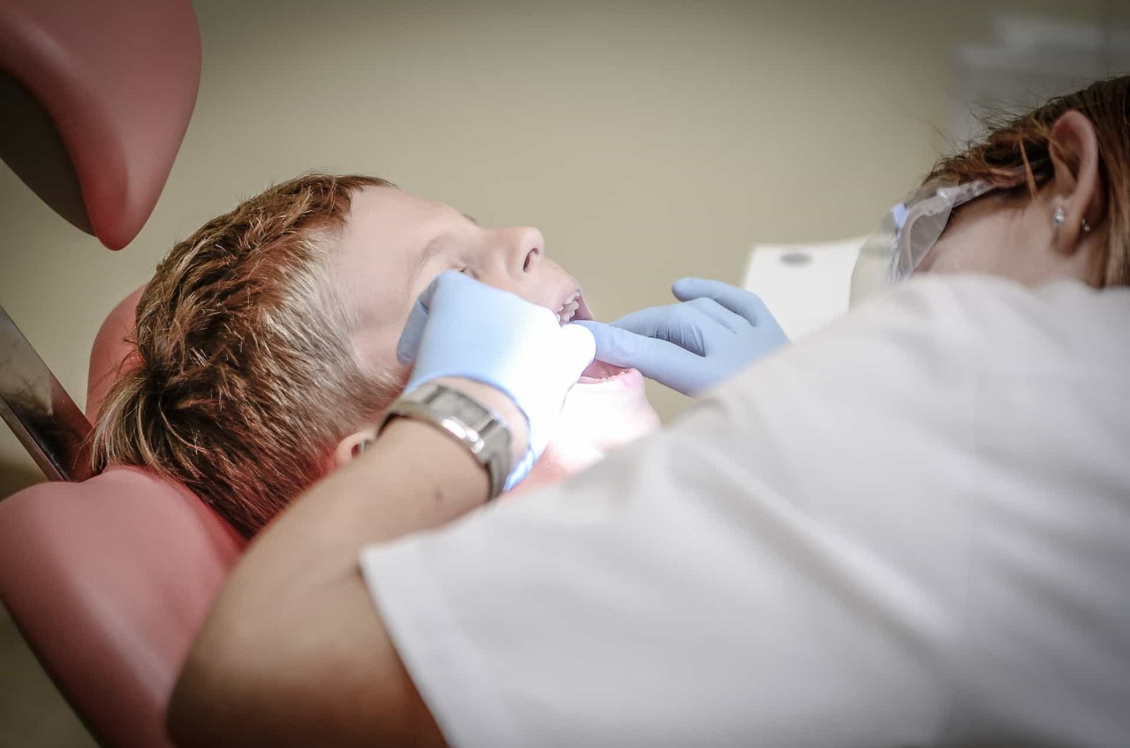 a dentist doing a check-up on a child with blonde hair